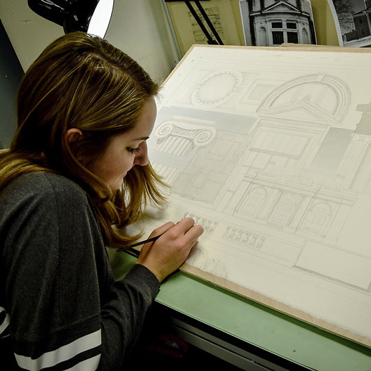 A student at a drafting table in Architecture class
