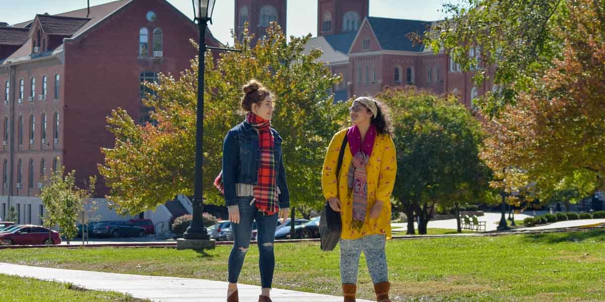 Two students walk together on campus