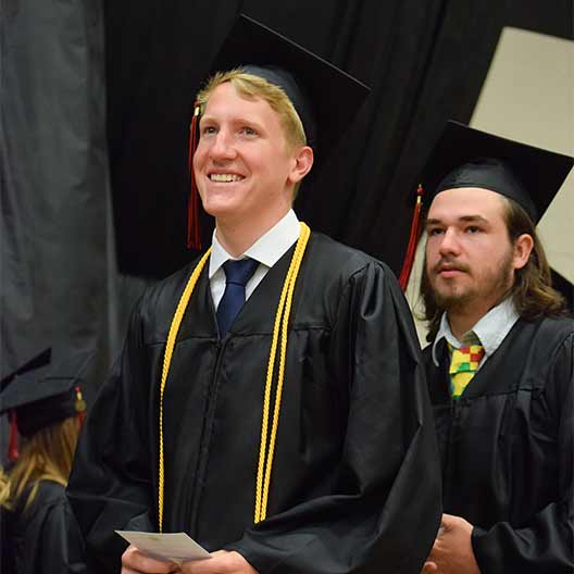 Graduating student smiling on his way to receive his diploma