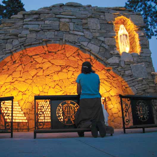 A woman prays at Mary's Grotto