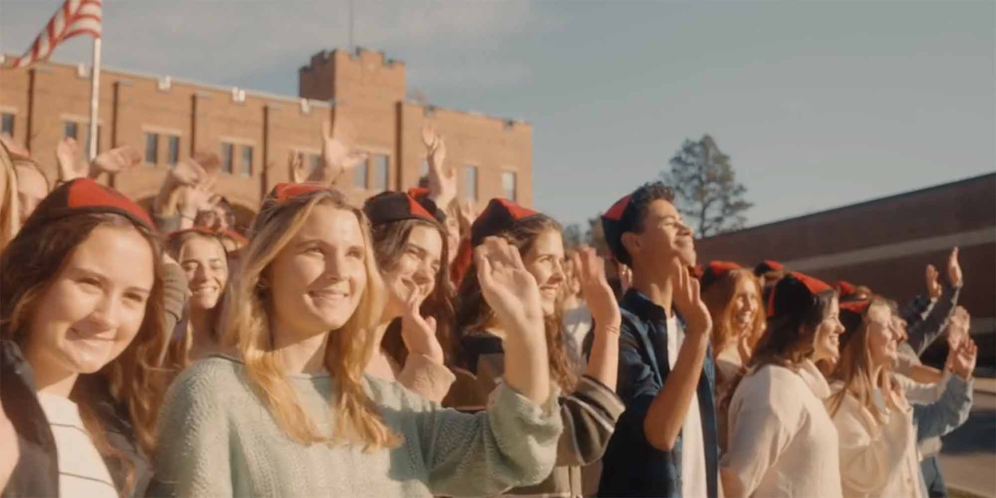Students in beanies waving