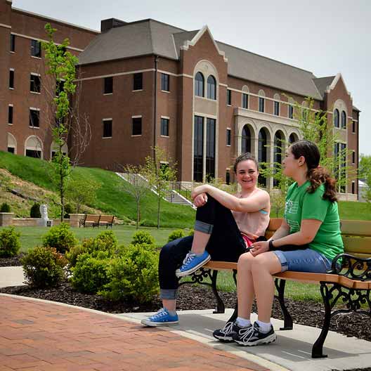Students relax in Raven Memorial Park, with Westerman Hall in the background
