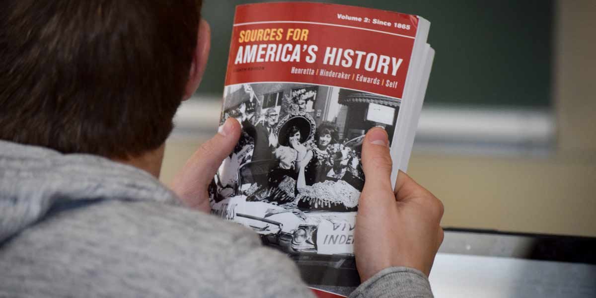 A student holds a history textbook in class