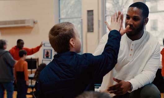 A Benedictine graduate works with a child at a community center