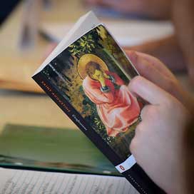 A student holds a copy of Confessions by St. Augustine of Hippo