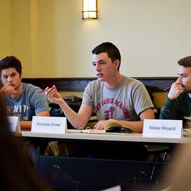 A student makes a point during a seminar class discussion