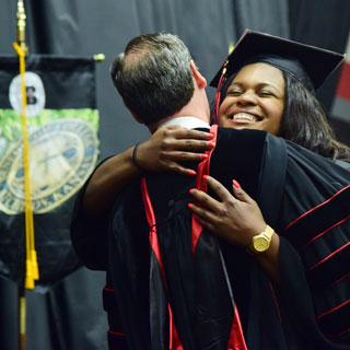 President Minnis hugging a graduate.