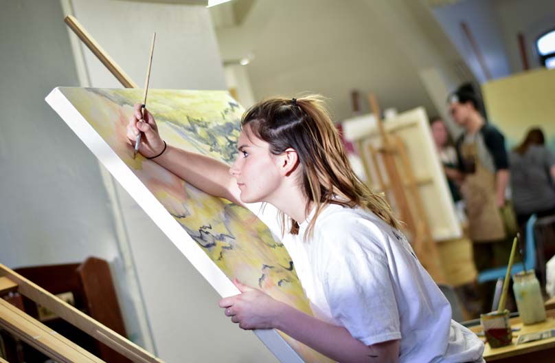 A student at a canvas in painting class