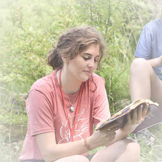 A student reads the Bible outdoors