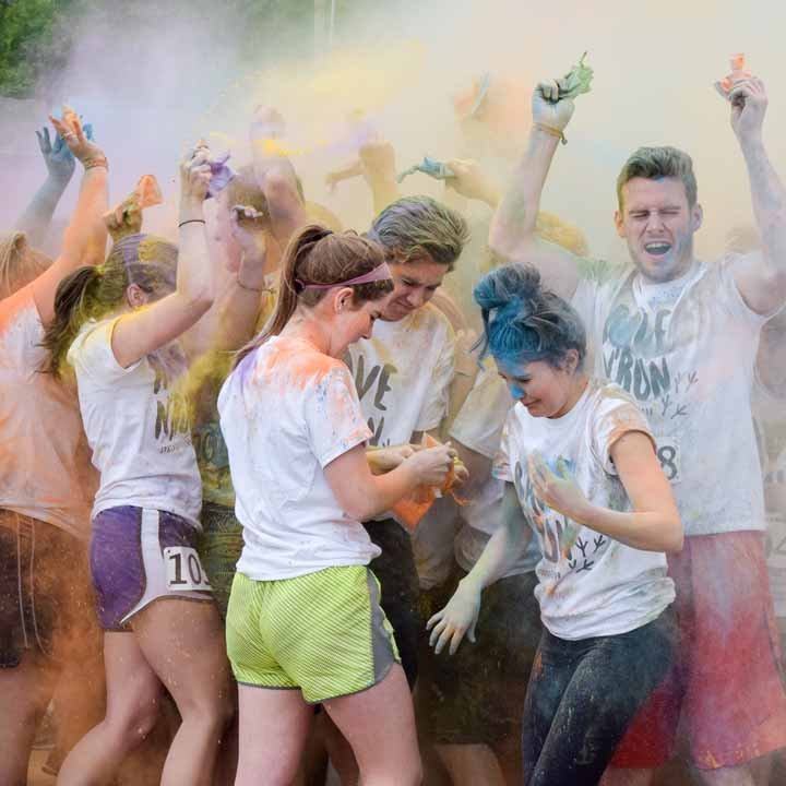 Students having fun in a cloud of brightly-colored powder at the Color Run
