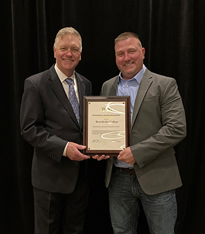 Benedictine grounds manager Michael Hagey (right) receives the PGMS Award from the society's president, Mark Feist.