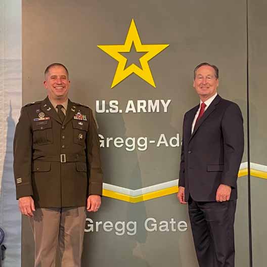 Benedictine College President Stephen Minnis in front of the new “Gregg Gate” with alumnus Lt. Col. Brian Carr ’03, who wrote the fort renaming order which was signed by the Secretary of the Army.